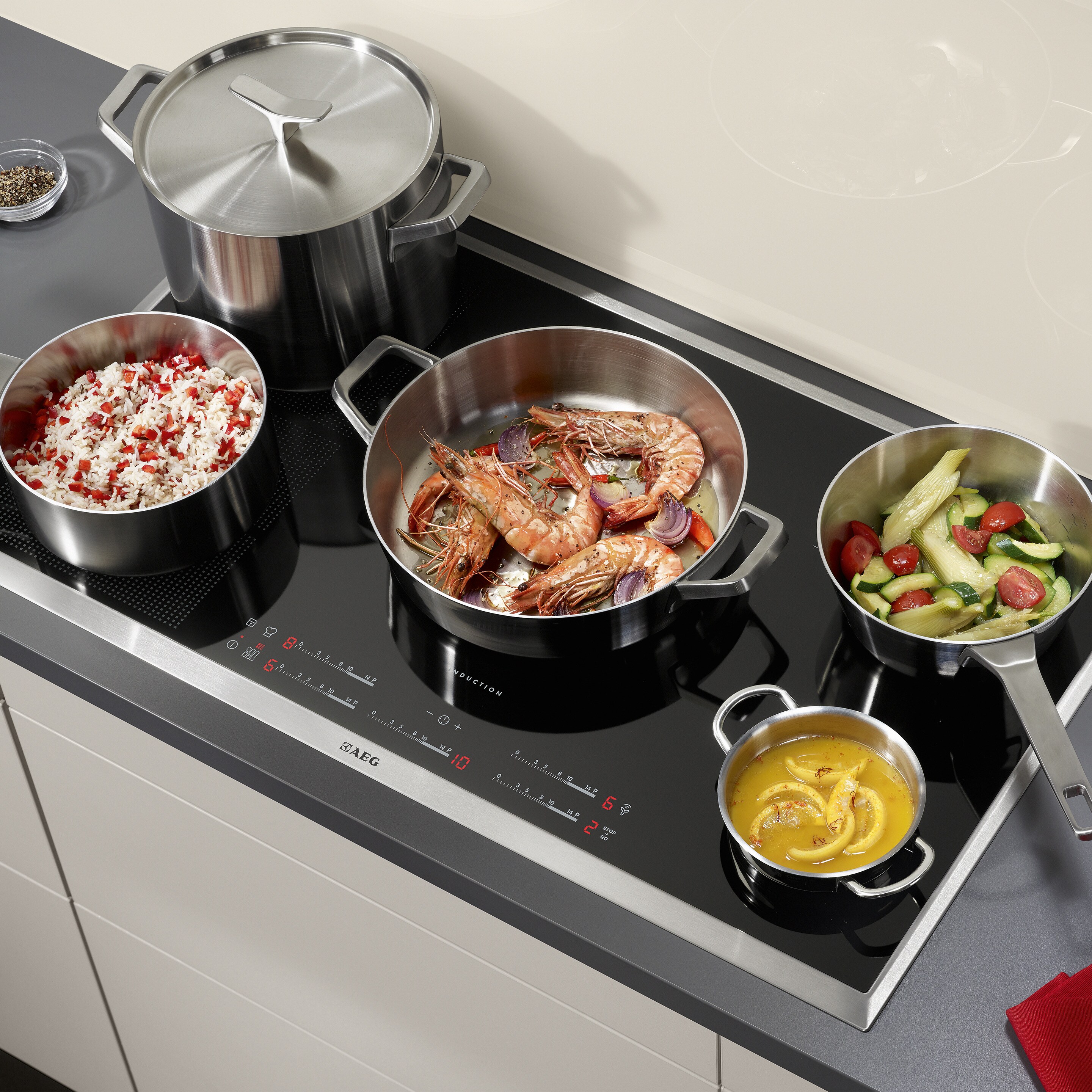 Індукційна варильна поверхня Electrolux, що використовується для приготування різних продуктів у сковорідках